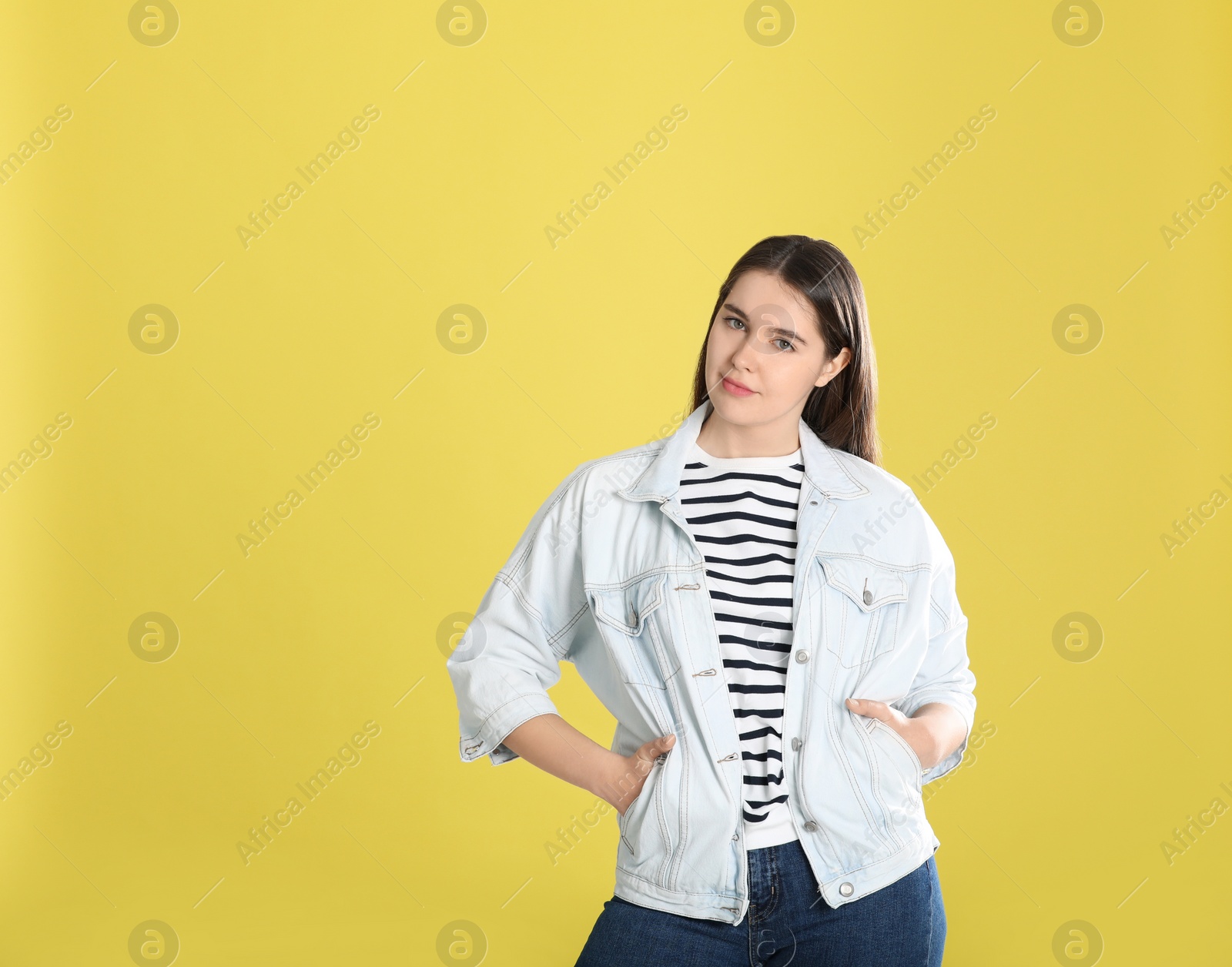 Photo of Portrait of young woman on yellow background. Space for text