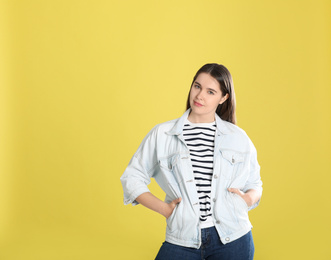 Portrait of young woman on yellow background. Space for text