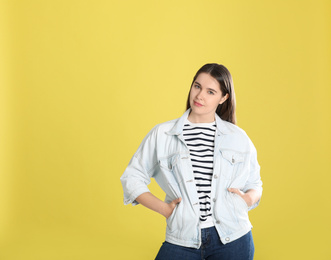 Photo of Portrait of young woman on yellow background. Space for text