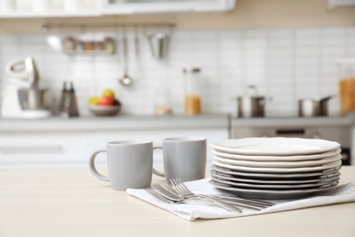 Photo of Tableware and blurred view of kitchen interior on background