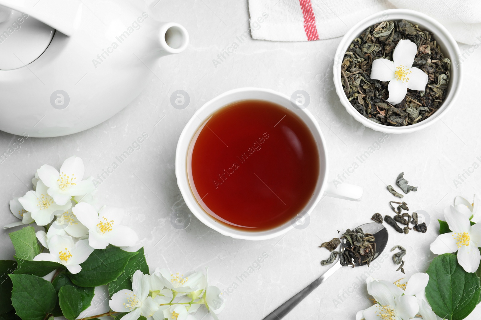 Photo of Flat lay composition with tea and fresh jasmine flowers on light grey marble table