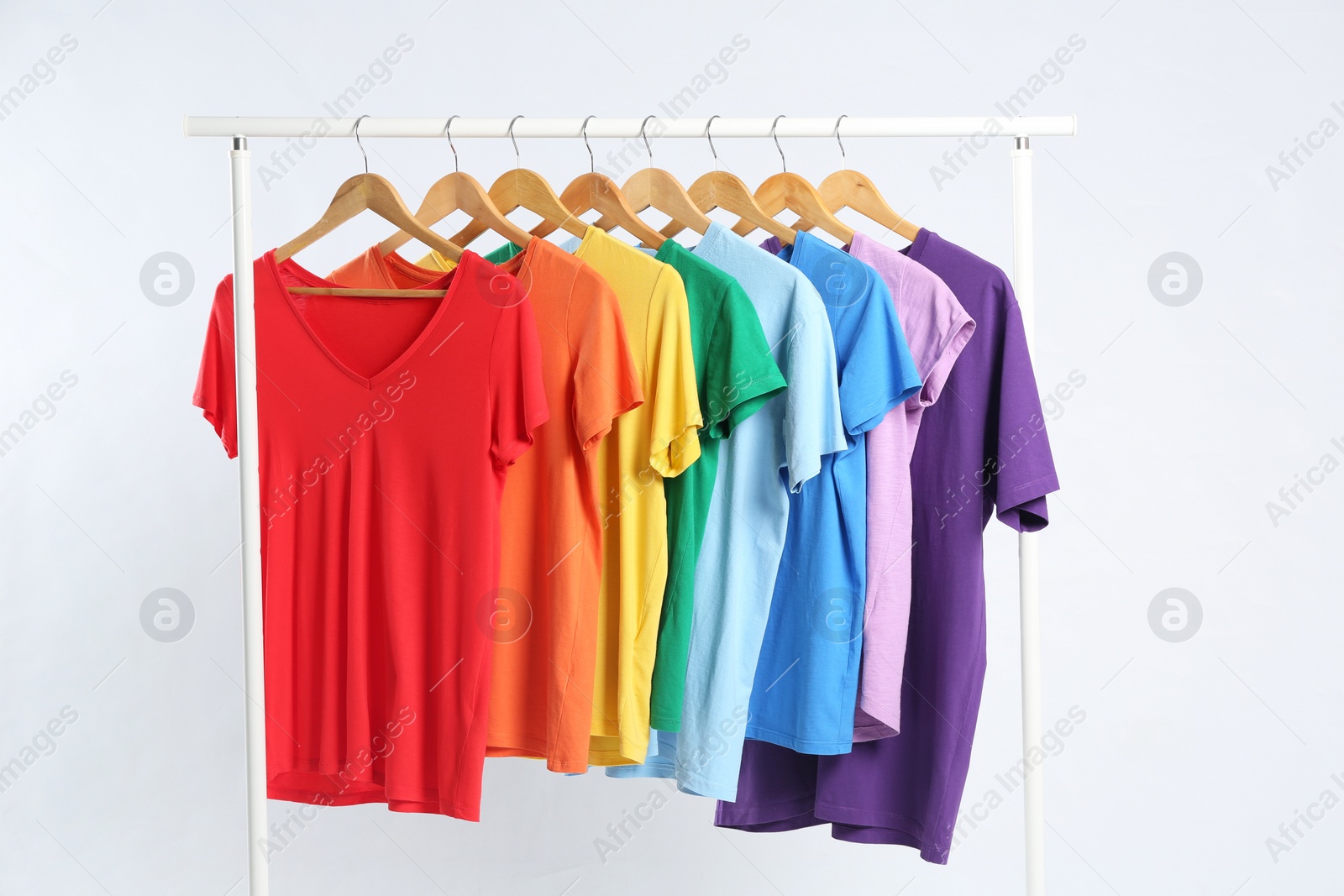 Photo of Colorful clothes hanging on rack against white background