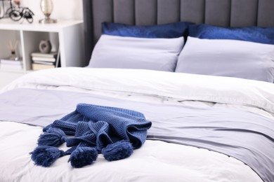 Photo of Soft blue plaid on bed in room, closeup