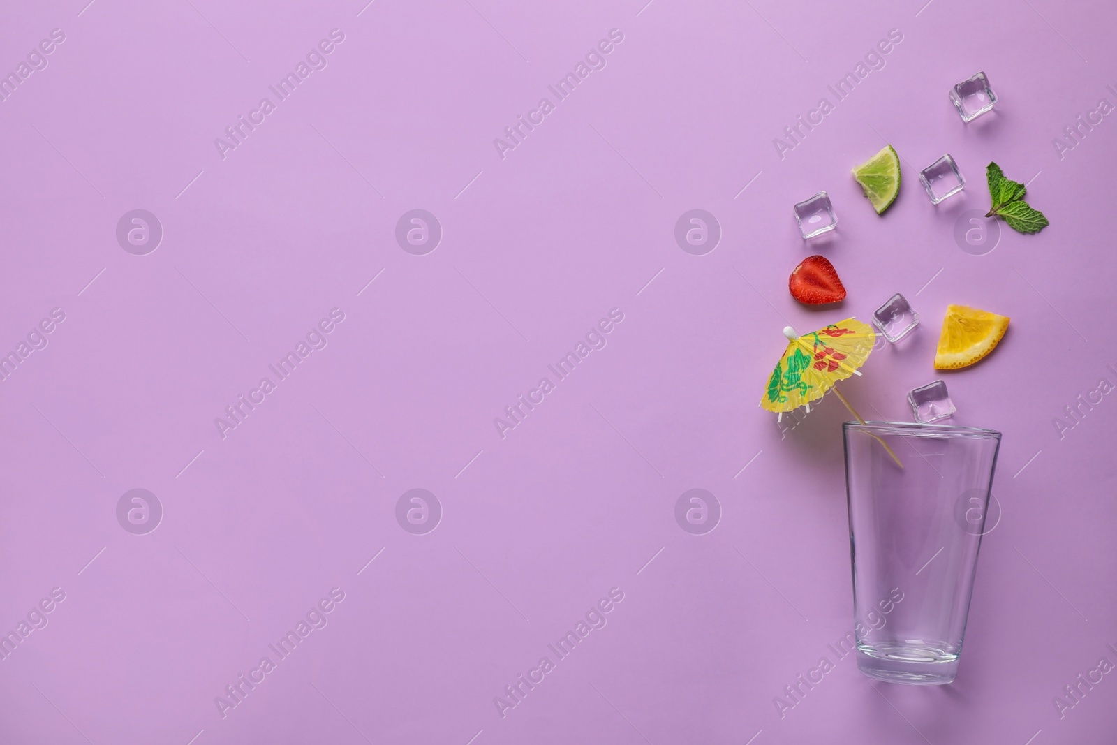 Photo of Flat lay composition with glass, ice and sliced fruits on color background, space for text. Summer cocktail recipe