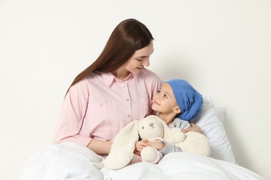 Photo of Childhood cancer. Mother and daughter with toy bunny in hospital