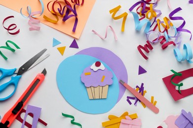 Flat lay composition with stationery, confetti and paper cupcake on white background