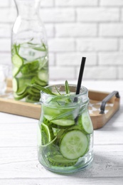 Photo of Natural lemonade with cucumber and rosemary in jar on table