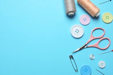 Photo of Flat lay composition with scissors and other sewing accessories on light blue background. Space for text