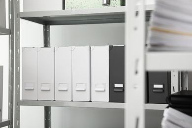 Folders with documents on shelf in archive