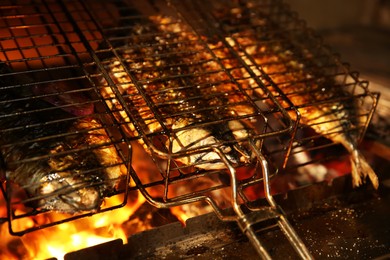 Photo of Grilling basket with whole fish in oven, closeup