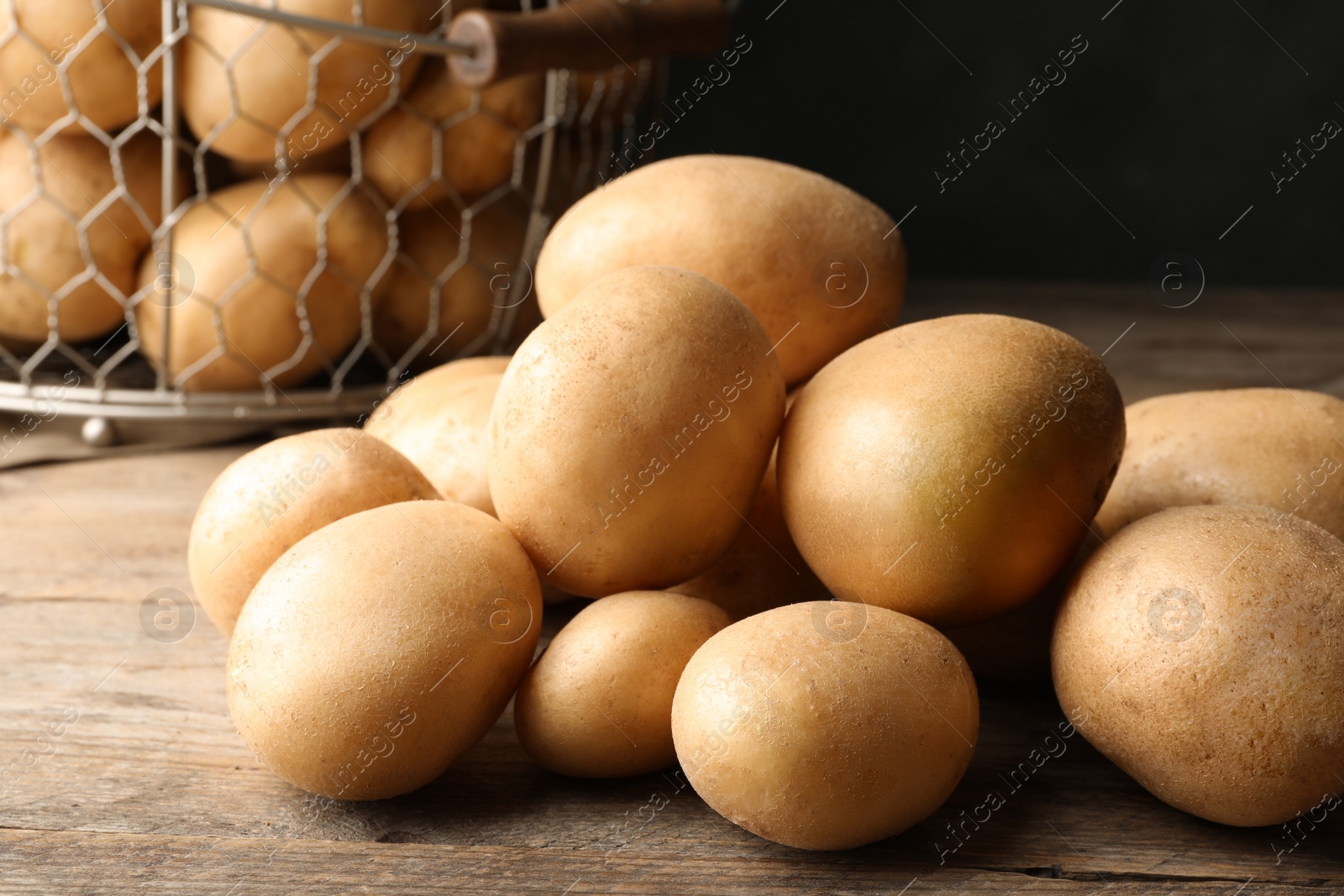 Photo of Raw fresh organic potatoes on wooden table, closeup