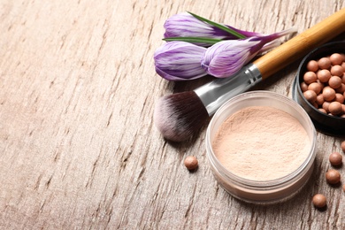 Photo of Makeup products and spring flowers on color background, space for text
