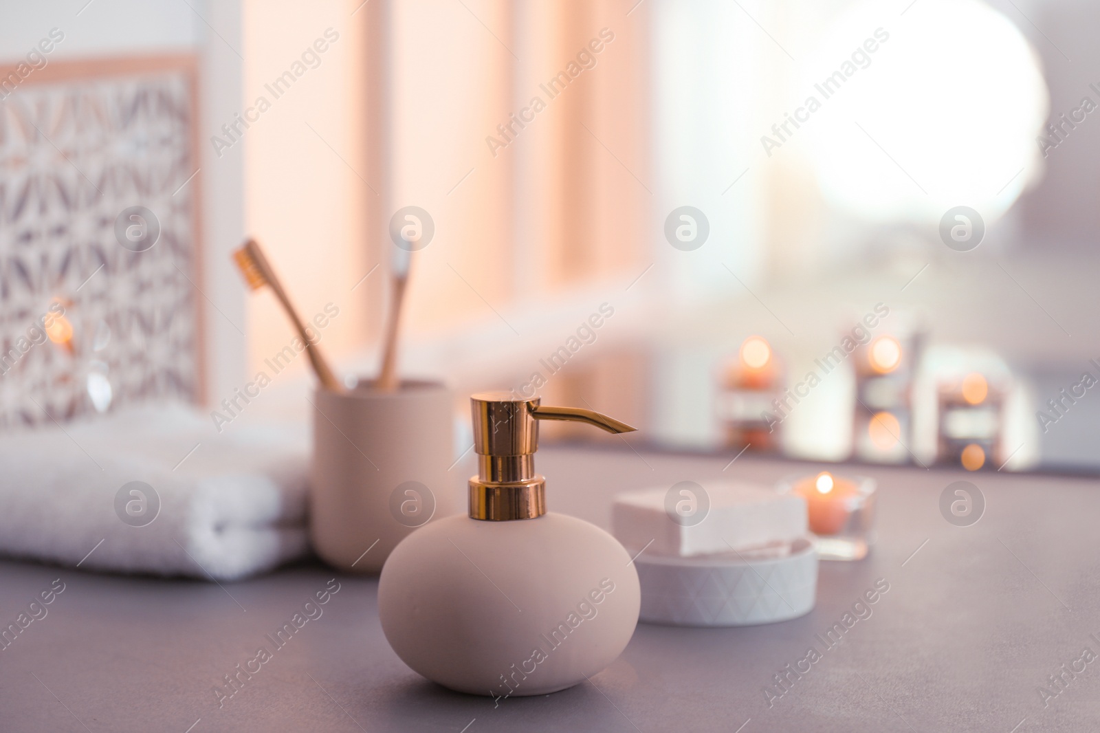 Photo of Bottle with liquid soap and toiletries on table against blurred background. Space for text