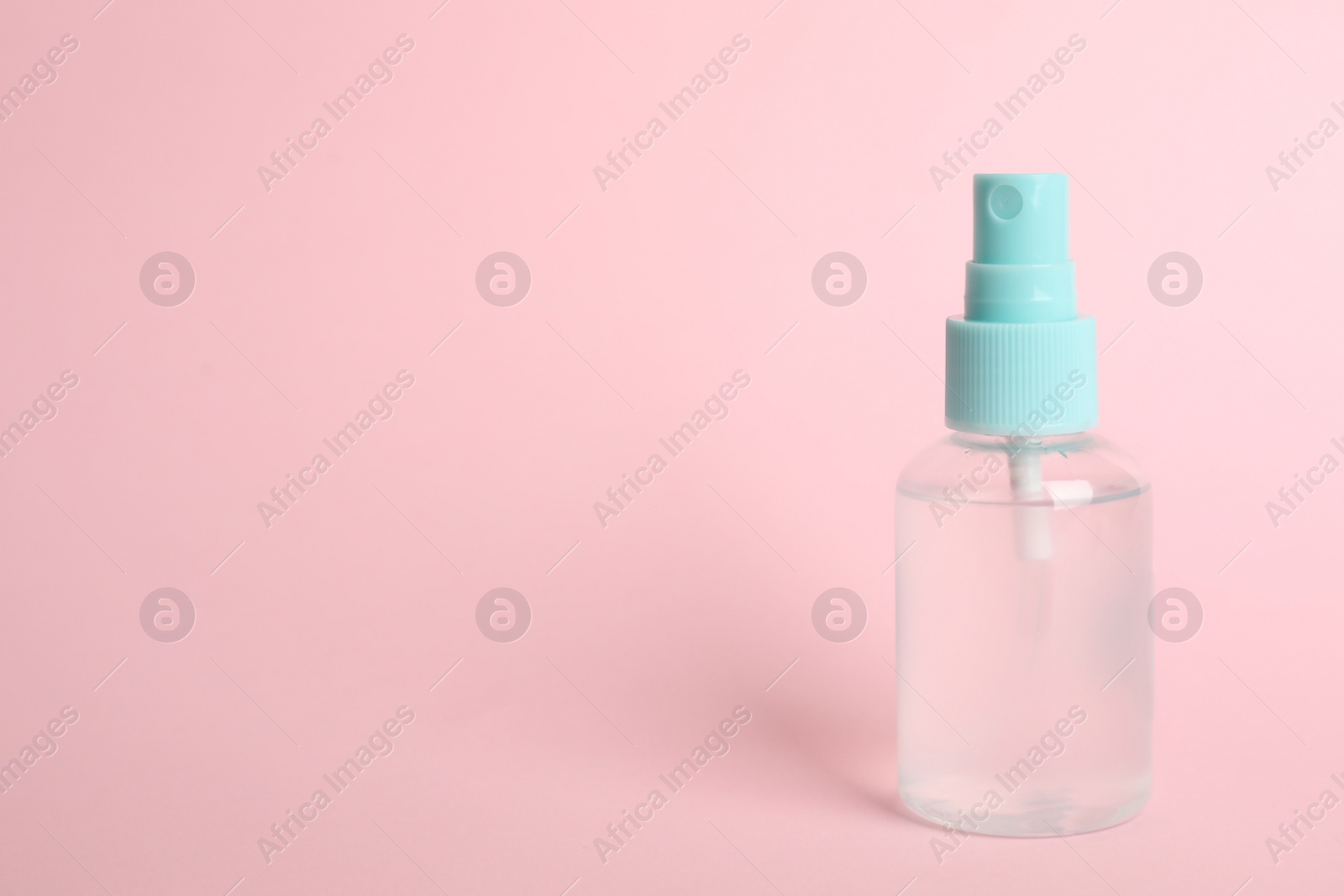 Photo of Antiseptic spray on pink background. Space for text
