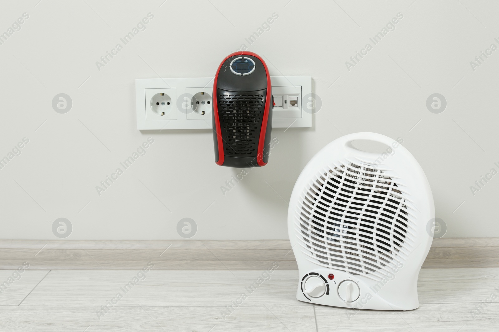 Photo of Modern electric compact and fan heaters indoors, space for text