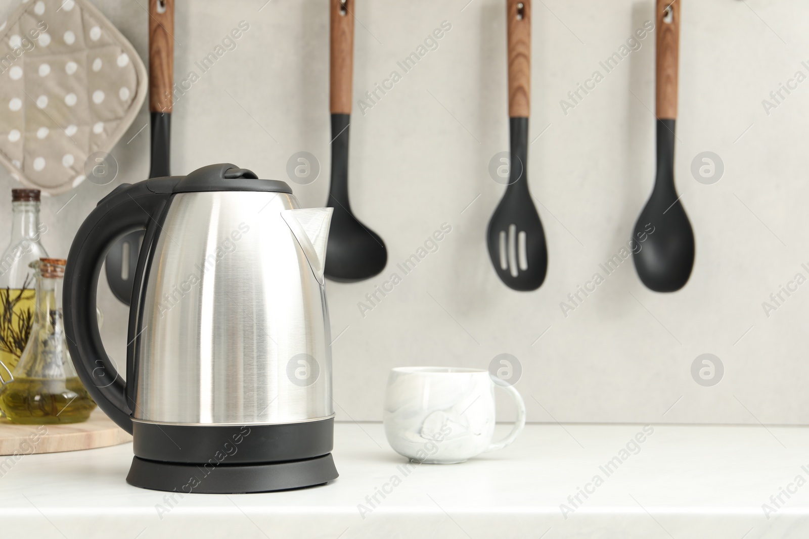 Photo of Electric kettle and cup on counter in kitchen