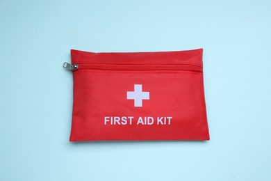 Photo of First aid kit on light blue background, top view