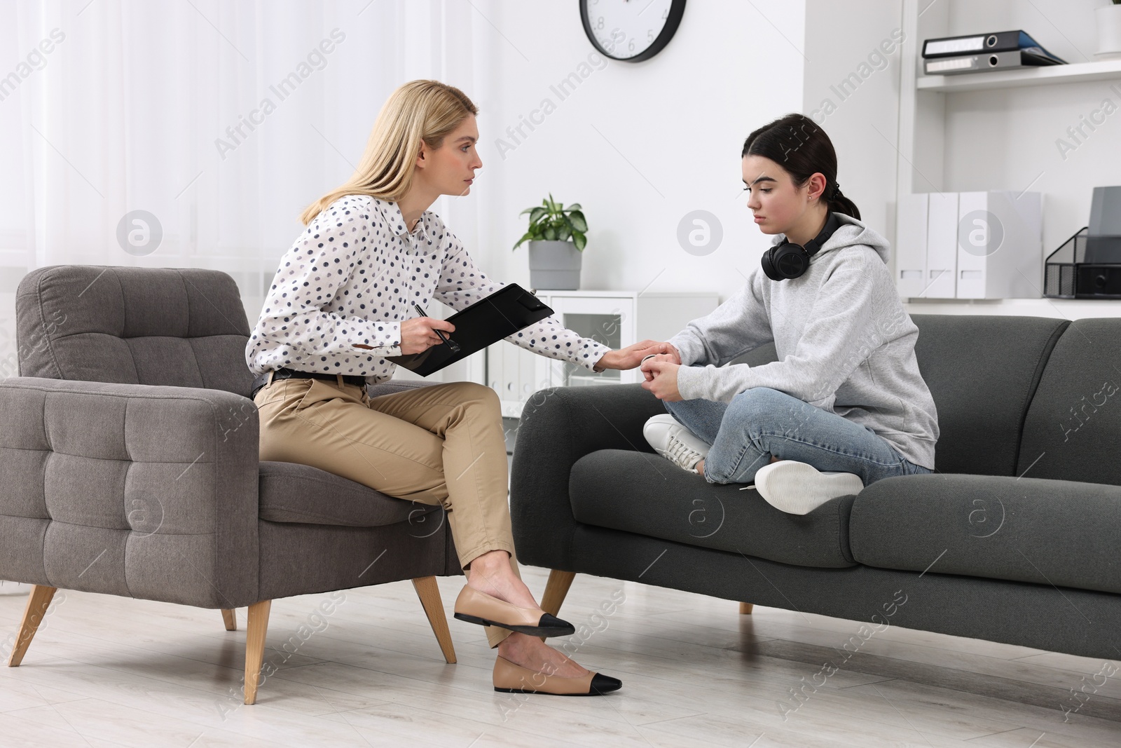 Photo of Psychologist working with teenage girl in office