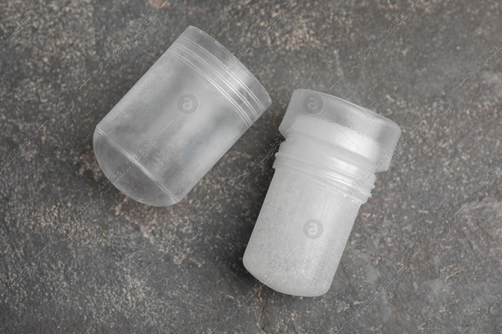 Photo of Natural crystal alum deodorant and cap on grey table, flat lay