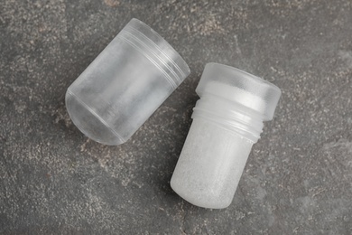 Photo of Natural crystal alum deodorant and cap on grey table, flat lay