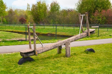 Photo of Old wooden seesaw in park. Outdoor recreation