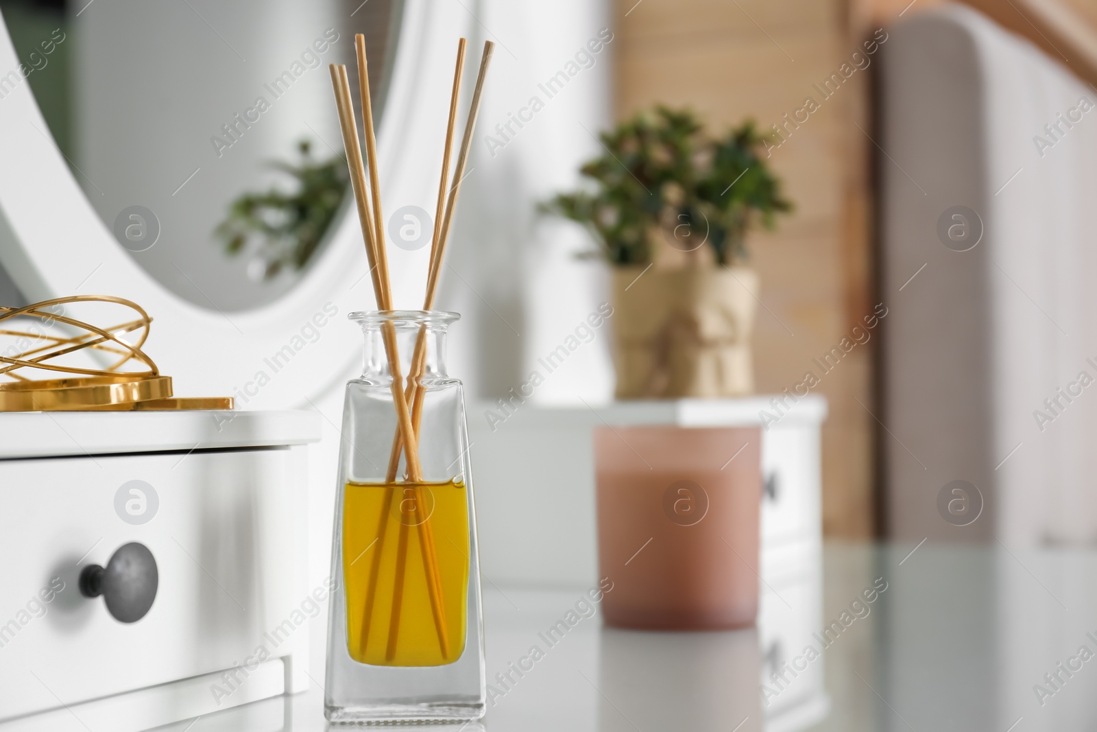 Photo of Aromatic reed air freshener on dressing table indoors. Space for text