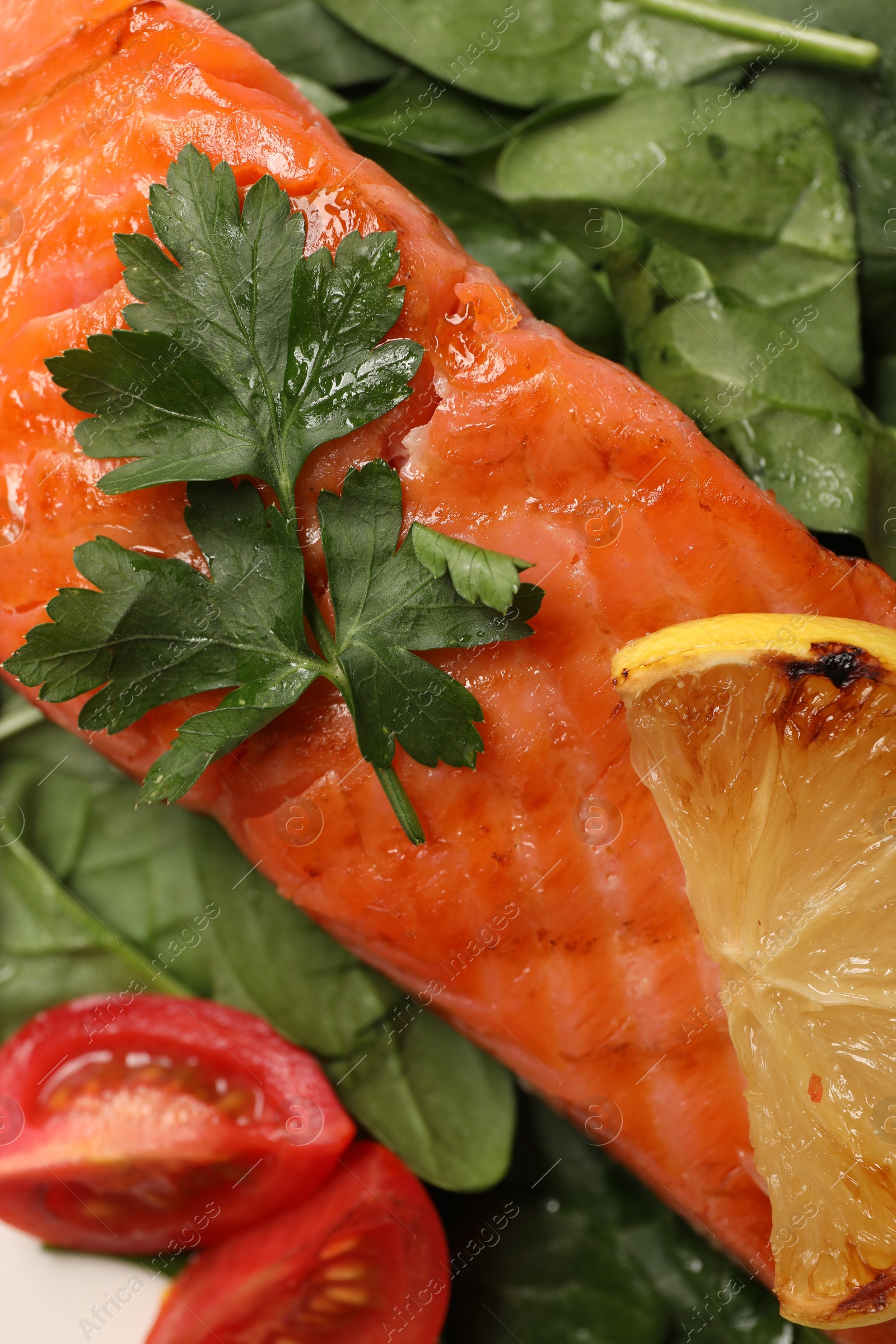 Photo of Tasty grilled salmon with tomatoes, lemon and basil, top view