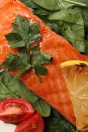 Photo of Tasty grilled salmon with tomatoes, lemon and basil, top view