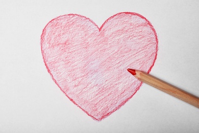 Photo of Drawing heart with pencil on sheet of paper, top view