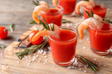 Photo of Delicious shrimp cocktail shots on wooden table