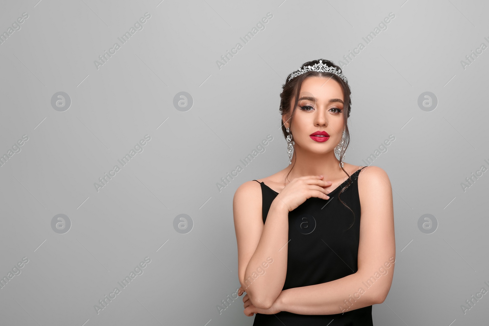 Photo of Beautiful young woman wearing luxurious tiara on light grey background, space for text