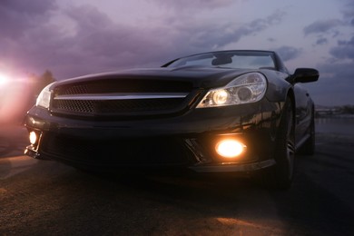 Luxury black convertible car outdoors in evening