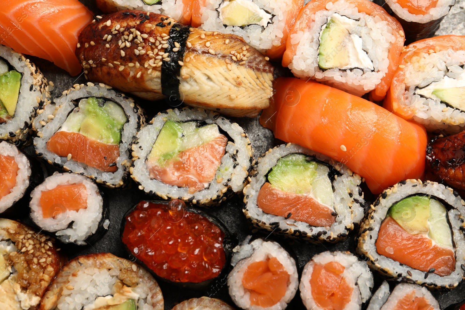 Photo of Different tasty sushi rolls as background, top view