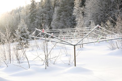 Photo of Outdoor clothes dryer and beautiful forest on winter day