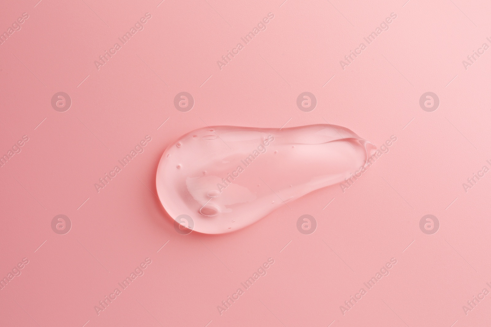 Photo of Sample of transparent gel on pink background, top view