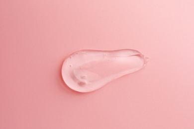 Photo of Sample of transparent gel on pink background, top view