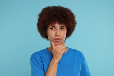 Photo of Portrait of thoughtful young woman on light blue background