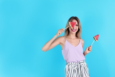 Pretty young woman with juicy watermelon on color background