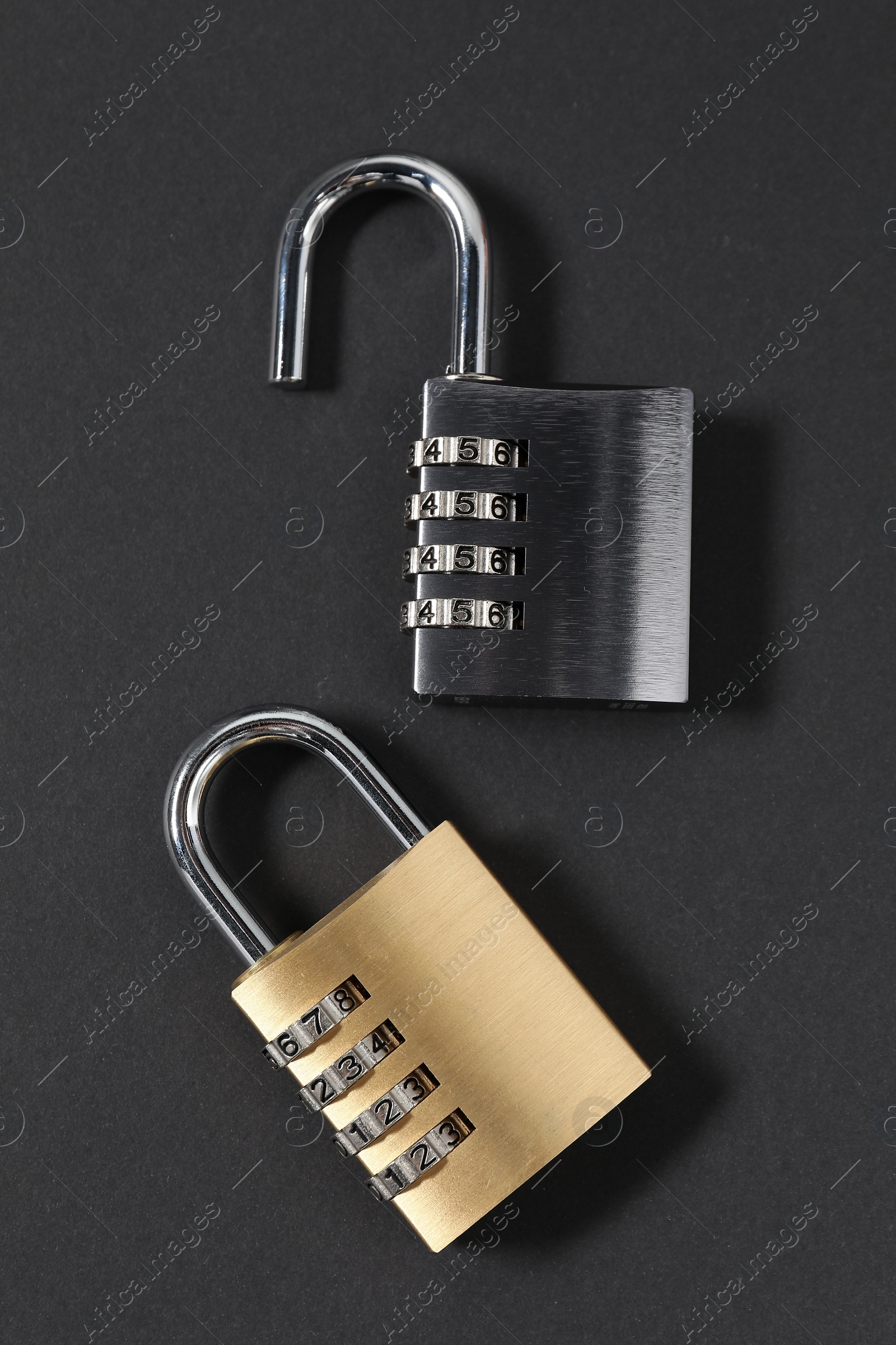 Photo of Steel combination padlocks on black background, top view