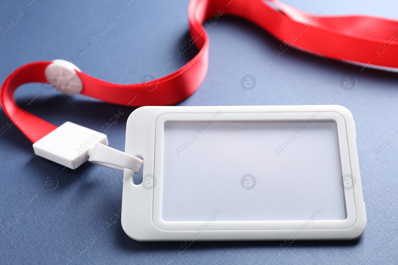 Photo of Blank badge with string on blue background, closeup