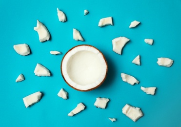 Fresh coconut pieces on blue background, flat lay