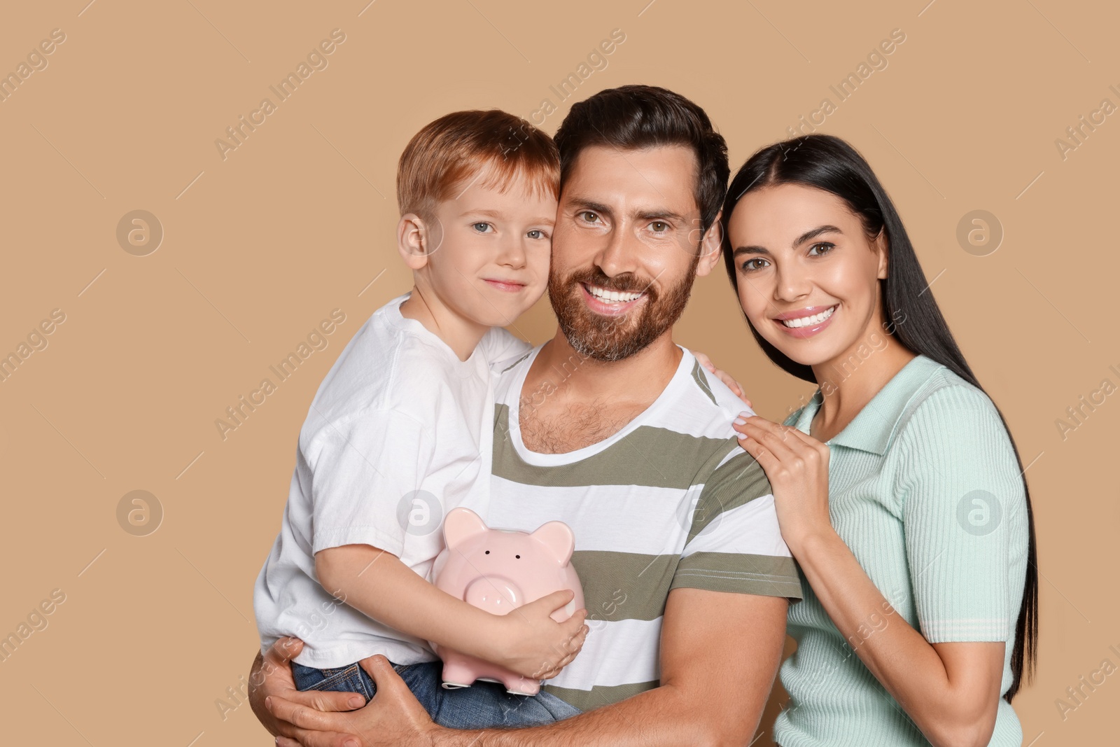 Photo of Happy family with ceramic piggy bank on beige background