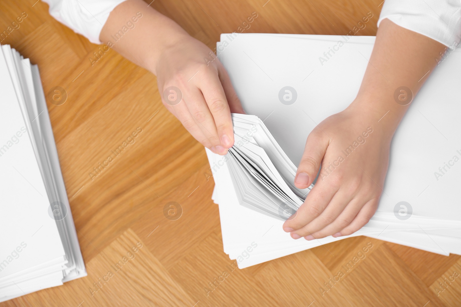 Photo of Man stacking documents at wooden table, top view