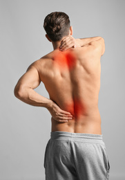 Image of Man suffering from pain in neck and lower back on light grey background