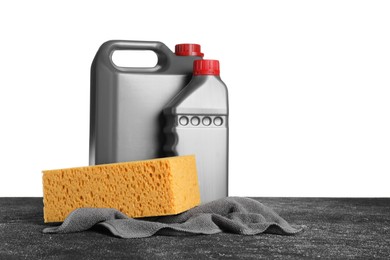 Photo of Bottles, cloth and car wash sponge on black table against white background