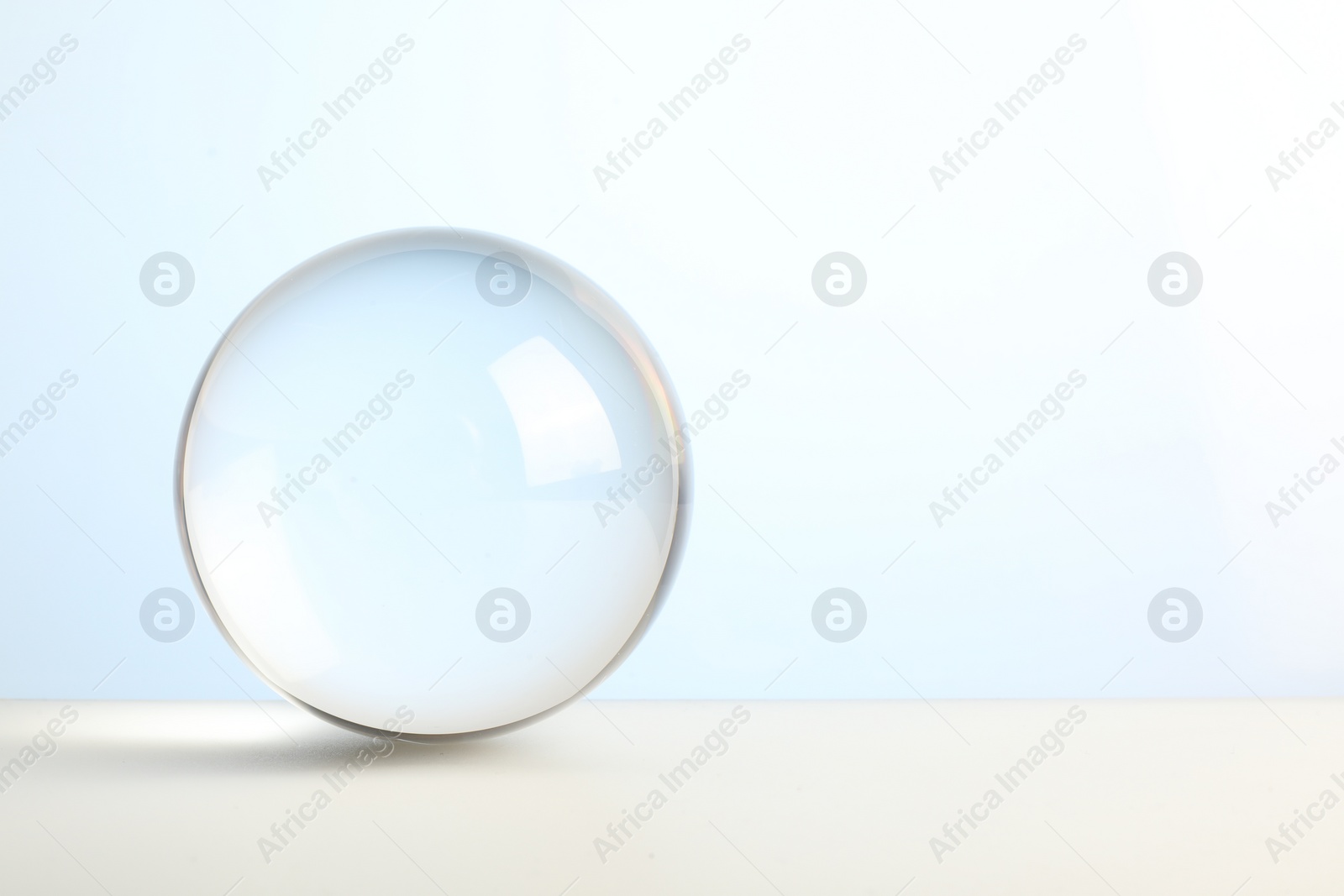 Photo of Transparent glass ball on white background. Space for text