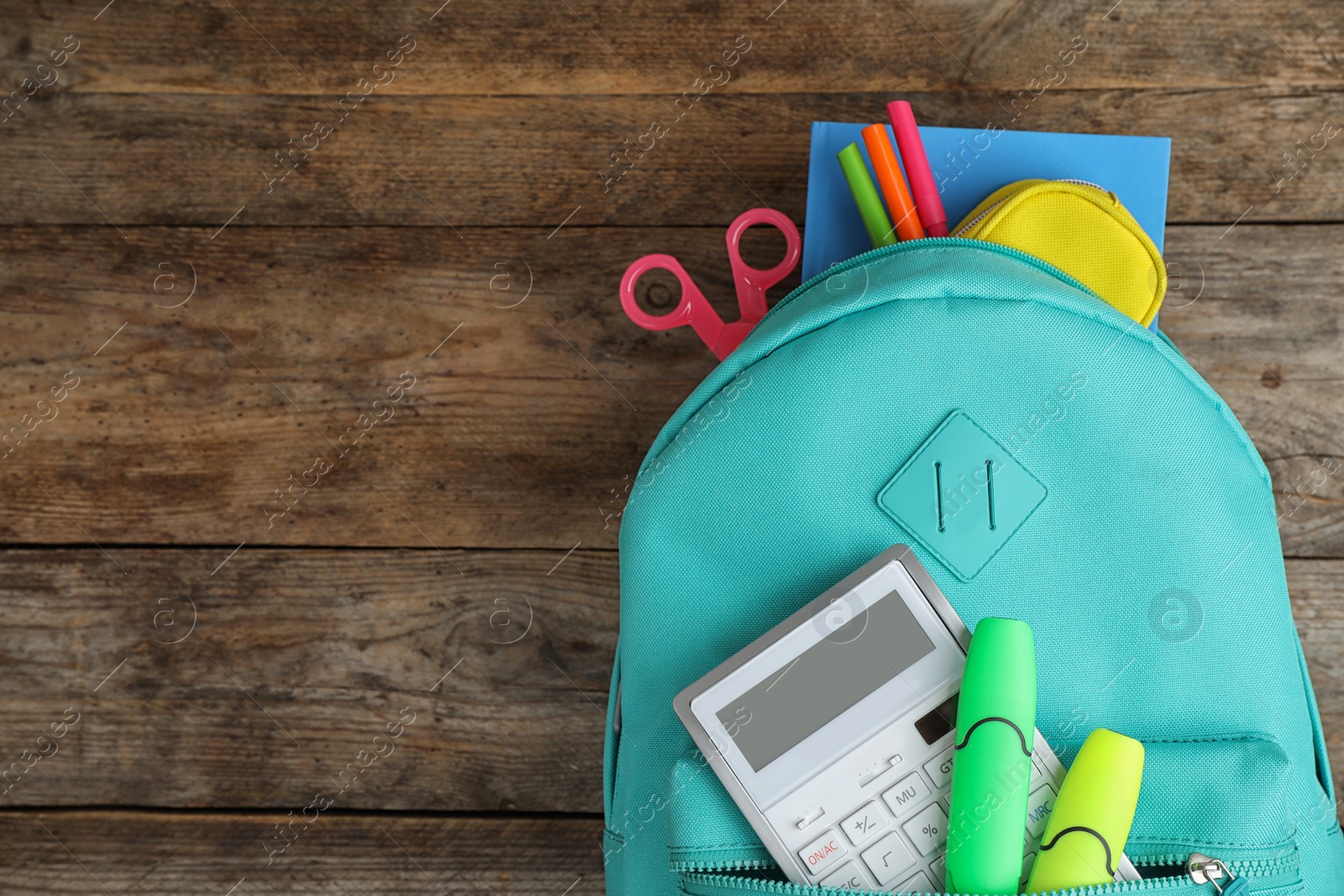 Photo of Stylish backpack with different school stationary on wooden table, top view. Space for text