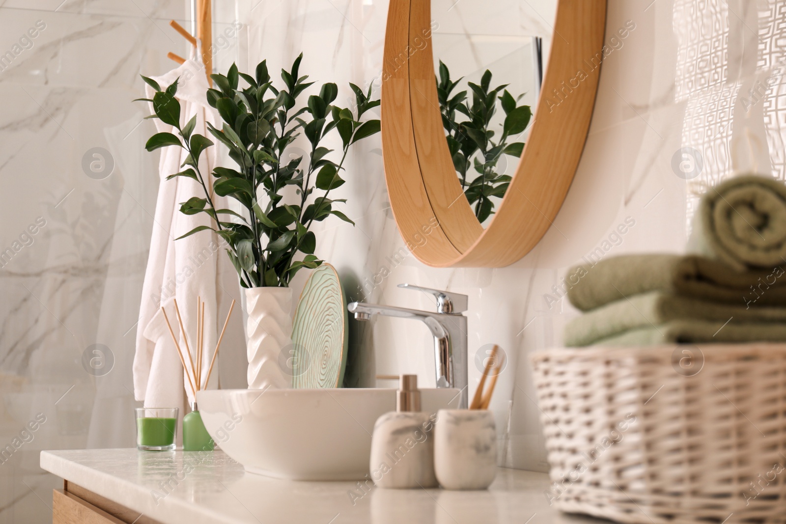 Photo of Vase with beautiful branches and toiletries near vessel sink in bathroom. Interior design