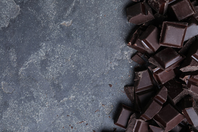 Photo of Delicious dark chocolate on light grey table, flat lay. Space for text