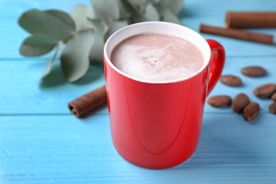 Composition with cup of tasty cocoa on blue wooden table